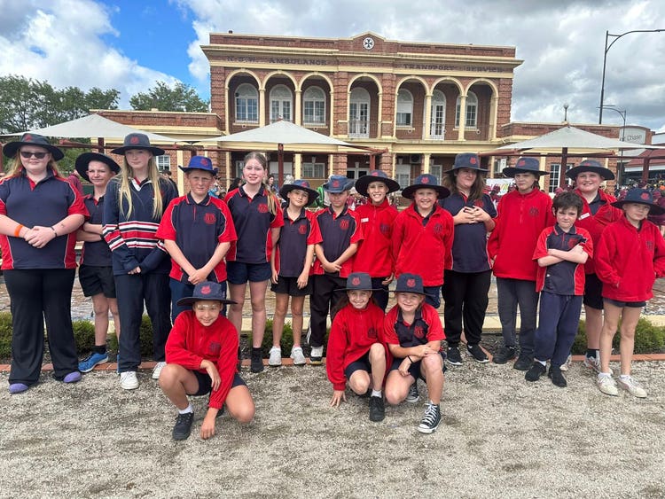 A group of students standing in front of a building in Bathurst after completing the NAIDOC march.