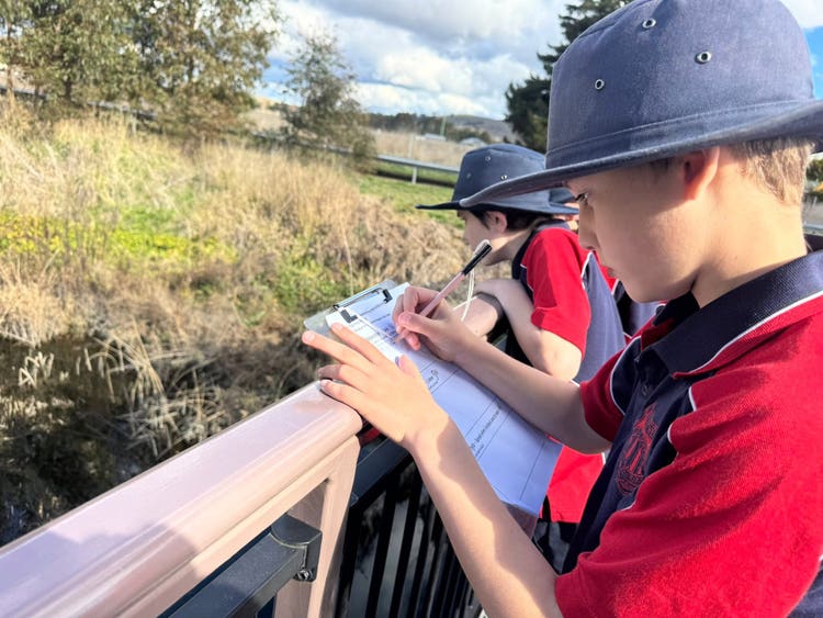 Some students recording information on a clipboard whilst on an excursion.
