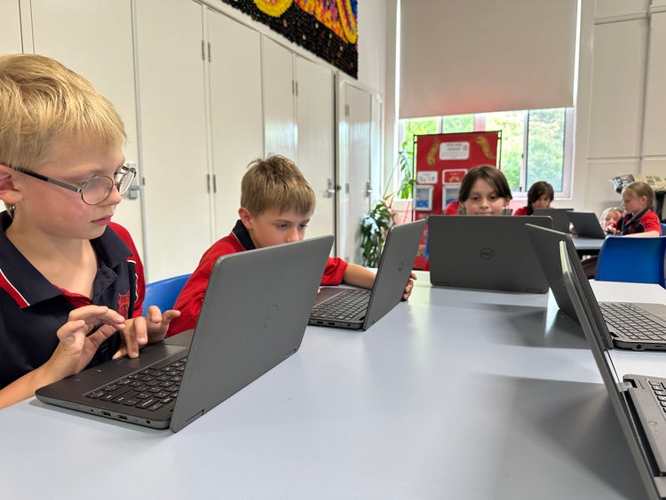 Students working on laptops in the technology room.