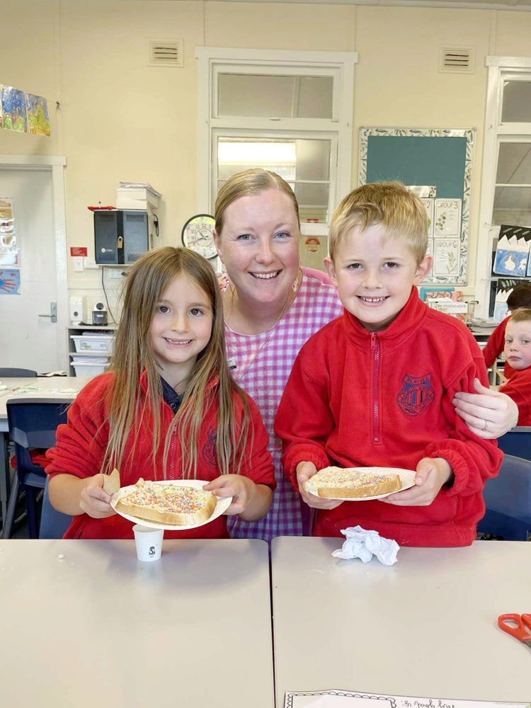 Two students showing their fairy bread they have made with their teacher.